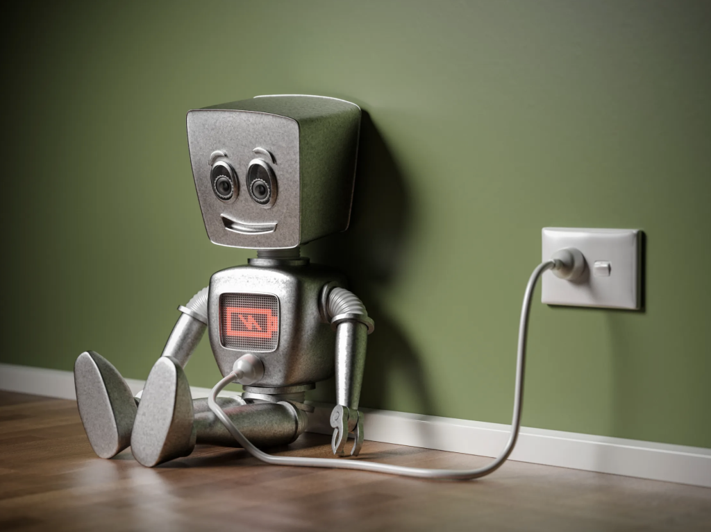 Robot pequeño conectado a una toma de corriente mostrando un indicador de batería baja.