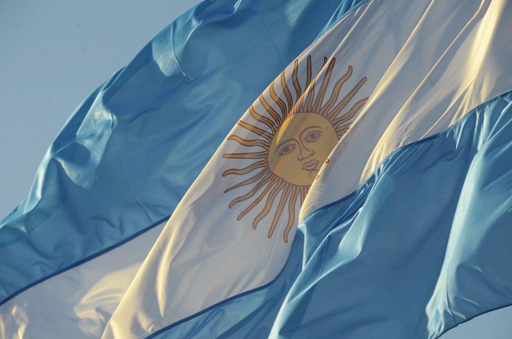 "Bandera de Argentina ondeando al viento, simbolizando la sobrerregulación de la inteligencia artificial en el país."